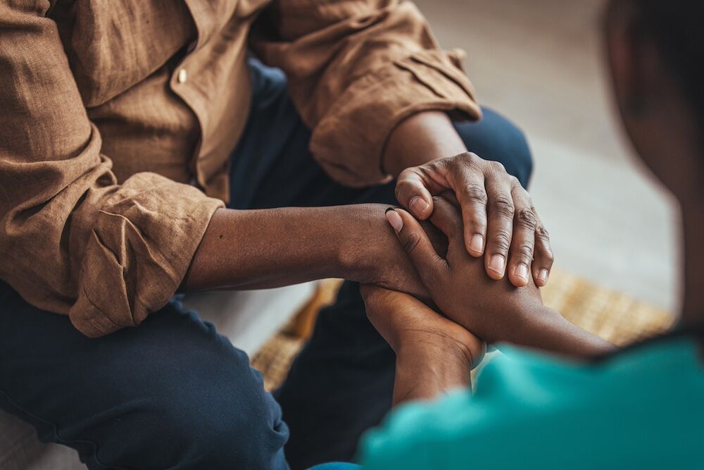 A senior man holding hands with a caregiver at the best memory care assisted living