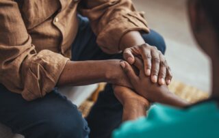 A senior man holding hands with a caregiver at the best memory care assisted living