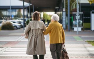 Caregiver walking senior in assisted living near San Dimas, CA