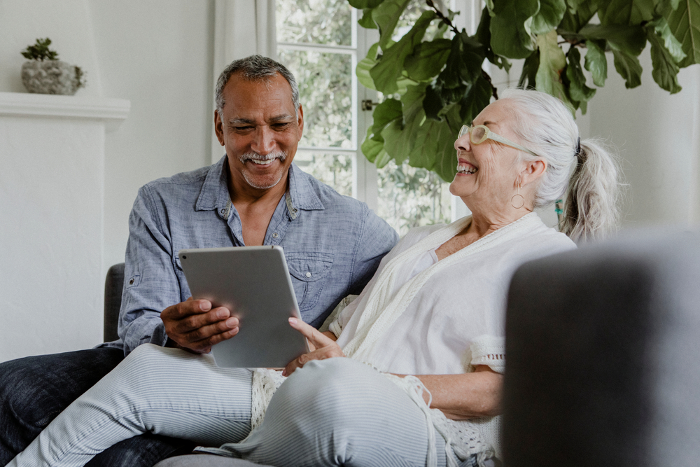 Senior couple on tablet in assisted living in San Gabriel Valley.