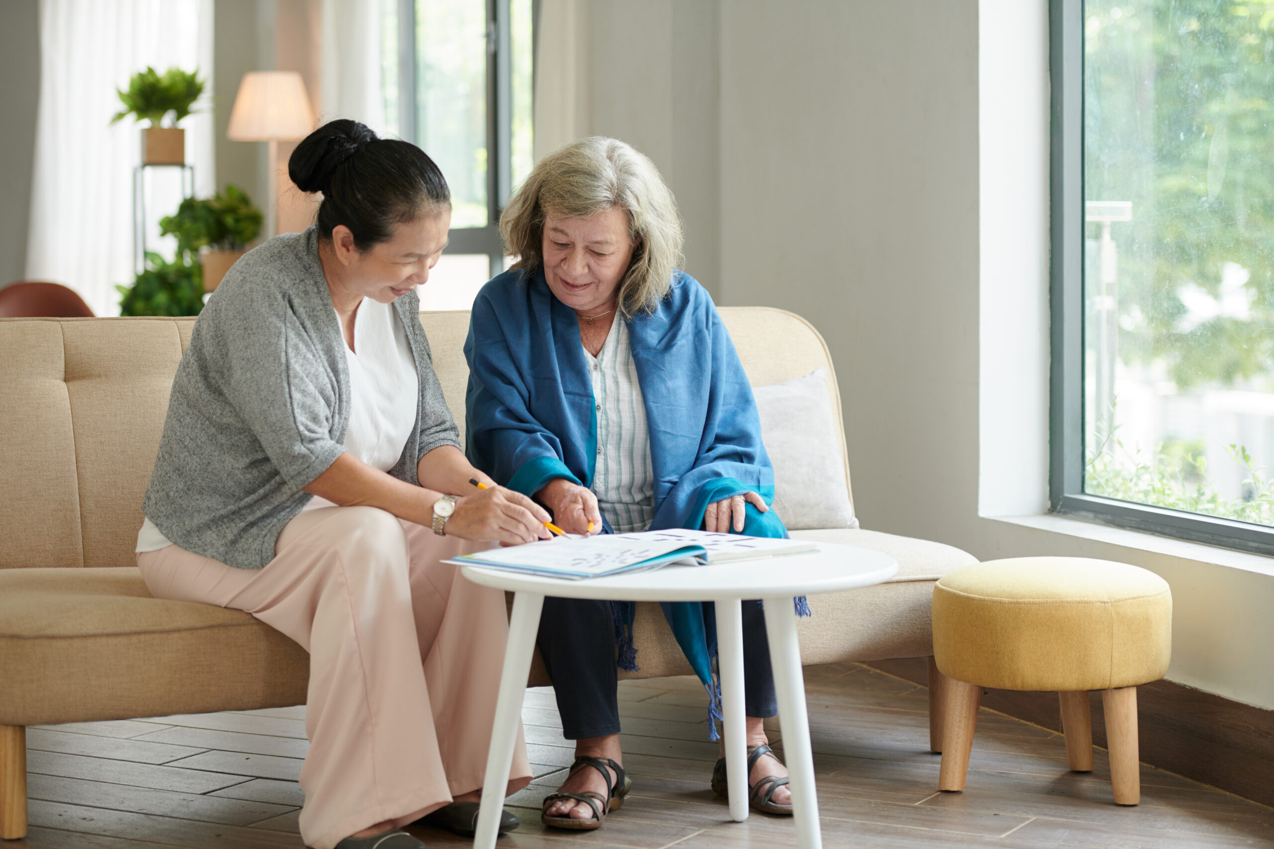 Woman doing crossword in memory care apartments.