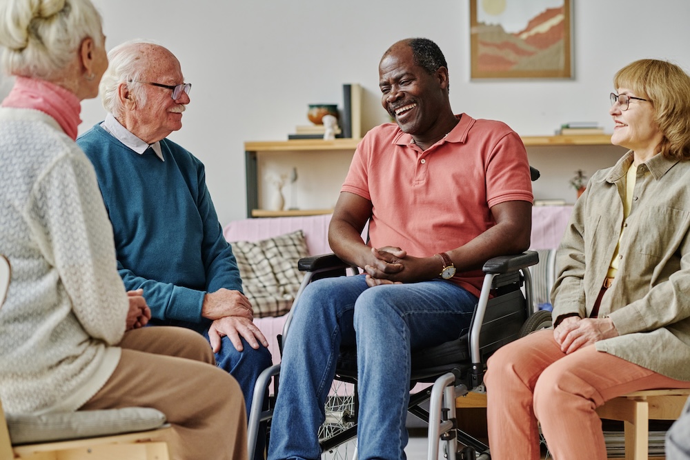 Group of seniors talking and laughing at their assisted living community
